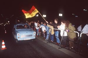 En Trabant – for mange selve symbolet på Østtyskland – hoster med sin totaktsmotor over Bösebrücke ved grænseovergangen Bornholmer Straße fra Øst- til Vestberlin den 9. november 1989 – den aften, da Berlinmuren faldt. Foto: AP/Sven Simon 