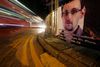 En bus i Hongkong kører forbi et banner til støtte for Edward Snowden. Foto: AP