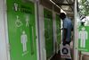 En inder tjekker sin mobiltelefon på en gade i Chennai, mens han venter på, at der bliver ledigt på det offentlige toilet. Premierminister Narendra Modi erklærede den 2. oktober, at alle indere nu har adgang til et toilet, offentligt eller privat, efter en massiv, fem år lang kampagne. Foto: Arun Sankar/AFP