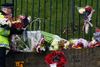 Beboere og kammerater til offeret lagde blomster på gadehjørner og foran kasernen. Bag afspærringerne blev buketterne lagt til rette af politiet. Foto: Sang Tan/AP
