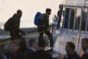 Migranter går om bord på en færge i den græske havneby Mytilini på øen Lesbos. De var et af de første hold, som mandag blev sendt retur til Tyrkiet som led i aftalen, der skal standse trafikken af irregulære migranter mellem Tyrkiet og Grækenland. Foto: Petros Giannakouris/AP