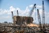 TOPSHOT - This picture taken on August 9, 2020 shows a view of the cranes at the port of Lebanon's capital Beirut, while in the background are seen the damaged grain silos opposite the blast site of a colossal explosion due to a huge pile of ammonium nitrate that had languished for years at a port warehouse. - The huge chemical explosion that hit Beirut's port, devastating large parts of the Lebanese capital and claiming over 150 lives, left a 43-metre (141 foot) deep crater, a security official said. The blast Tuesday, which was felt across the country and as far as the island of Cyprus, was recorded by the sensors of the American Institute of Geophysics (USGS) as having the power of a magnitude 3.3 earthquake. (Photo by PATRICK BAZ / AFP)