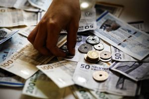     HÂnd samler m¯nt op blandt danske kontanter, m¯nter, pengesedler, penge.  Foto: Lærke Posselt