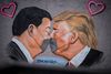 Billedkunstneren Eme Freethinker har malet Donald Trump og Xi Jinping, der kysser hinanden iført mundbind på en rest af Berlinmuren. Foto: imago-images/Scanpix