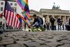 En mand lægger blomster ved den amerikanske ambassade i Berlin. Foto: Markus Schreiber/AP