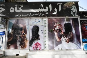 Ansigterne på kvinderne på skønhedssalonens facade blev malet over med sort spraymaling, da Taliban rykkede ind i Kabul. Nye tider venter den afghanske befolkning efter 20 år, hvor vestlige værdier har forsøgt at vinde indpas. Foto: Wakil Kohsar/AFP