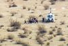 Rumfartøjet SpaceShipTwo styrtede ned i en ørken i USA. Her bærer redningsfolk en person på en båre til en ventede helikopter.