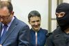 Nadja Savtjenko i et glasbur i retssalen i den russiske by Donetsk – omgivet af sin advokat, Nikolaj Polozov og en russisk politimand. Foto fra video: AP