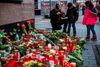 Fredag blev der lagt blomster og tændt lys uden for caféen "Midnight", som onsdag var mål for et racistisk motiveret angreb. Foto: Odd Andersen/AFP