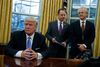 Donald Trump har indtaget Det Ovale Kontor, hvor han han mandag aften underskrev en række dekreter. Foto: AP Photo/Evan Vucci.