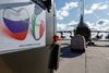 Ruslands forsvarsministerium tog fotos af forberedelserne til at sende miltære eksperter til Italien. Kærlig hilsen fra Rusland står der på banneret. Foto: AFP