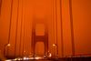 TOPSHOT - Cars drive along the San Francisco Bay Bridge under an orange smoke filled sky at midday in San Francisco, California on September 9, 2020. - More than 300, 000 acres are burning across the northwestern state including 35 major wildfires, with at least five towns "substantially destroyed" and mass evacuations taking place. (Photo by Harold POSTIC / AFP)