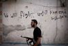En soldat fra Den Frie Syriske hær på vandring i den sønderbombede by Aleppo i Syrien. Oprørsstyrkerne i bye ner presset på to fronter af Assad-tropper og islamisterne fra Islamisk Stat, og ifølge Forsvarets Efterretningstjeneste er der risiko for, at oprørerne hele mister byen.