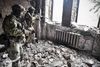 To russiske soldater på patrulje den 12. april i Mariupols teater, som russiske bomber angiveligt ramte den 16. marts. I bygningen befandt sig ifølge lokale ukrainske myndigheder flere hundrede børn, kvinder og gamle. Adskillige af disse skulle ifølge de samme kilder være afgået ved døden under det russiske angreb. Foto: Alexander Nemenov/AFP