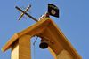 I den irakiske by Mosul bliver et kors udskiftet med Islamisk Stats flag.