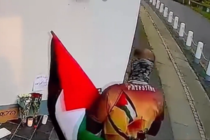 En video delt af den israelske ambassade viser mænd med et palæstinensisk flag vandalisere blomsterbuketter, som var blevet lagt ved ambassaden.