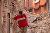 TOPSHOT - A resident navigates through the rubble following a 6.8-magnitude quake in Marrakesh on September 9, 2023. A powerful earthquake that shook Morocco late September 8 killed more than 600 people, interior ministry figures showed, sending terrified residents fleeing their homes in the middle of the night. (Photo by FADEL SENNA / AFP)