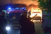 Politiet står vagt, mens brandfolkene slukker en brand.