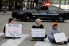 Tre demonstranter blokerede vejen ved Public Square i Cleveland, Ohio, torsdag. Efter to års undersøgelse beskylder en rapport politiet i Cleveland for alt for ofte at anvende overdreven og unødvendig magt. I flere situationer var politiets opførsel med til at optrappe ellers ufarlige situationer, så de endte i vold. Foto Tony Dejak/AP