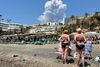 Strandgæster ved Playa del Bajondillo i Torremolinos ser på røgskyerne fra en voldsom brand i Malaga. Foto: Hannah McKay TPX/Reuters