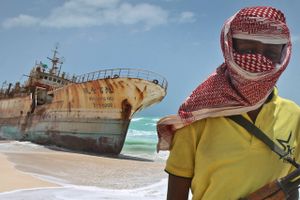 En somalisk pirat ved et skib, der er gået på grund. 