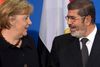 Muhammed Mursi og Angela Merkel i Berlin i går. Den egyptiske præsident aflyste derimod en vidererejse til Paris.