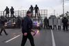 Efter at titusinder søndag havde demonstreret imod den hviderussiske præsident, Aleksandr Lukasjenko, fløj han hen over folkemængden i helikopter bevæbnet med en riffel. Billedet her er fra en video, som det statsejede tv har offentliggjort. Det viser Lukasjenko ved landingen, hvor medlemmer af hans sikkerhedsstyrker tager imod ham. Foto: AFP