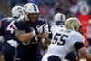 Connecticuts offensive lineman Andreas Knappe (med front mod kameraet) blokerer Navy linebacker Ted Colburn (55) i fjerde quarter af et opgør i NCAA i setember 2015. Foto: Stew Milne/AP
