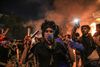 En demonstrant i den hellige by Karbala i Irak gør sejrstegn med tåregaspatroner på fingrene. I søndags gik demonstranterne til angreb på Irans konsulat i Karbala i raseri over præstestyrets dominans. Foto: AFP