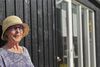 At Lisbeth Benee Olsen er en farveglad dame fornægter sig ikke – det ses ved første øjekast på de koboltblå briller. Her står hun på terrassen med udsigt mod vest, hvor solnedgangen kan nydes over marehalmen hver aften. Foto: Ulrik Bang