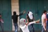 Den voldelige konflikt mellem Israel og palæstinenserne, der er eskaleret de seneste uger, bliver fulgt tæt af danske muslimer, hvoraf halvdelen ifølge en måling ikke mener, at Israel har ret til at eksistere. Her er det en palæstinensisk kvinde, der tirsdag skyder med slangebøsse mod israelske tropper på Vestbredden. Foto: Nasser Shiyoukhi/AP