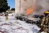 Israeli fire brigade teams douse the blaze in a partking lot outside a residential building following a rocket attack from the Gaza Strip in the southern Israeli city of Ashkelon, on October 7, 2023. Palestinian militant group Hamas has launched a "war" against Israel, Defence Minister Yoav Gallant said, after barrages of rockets were fired from the Gaza Strip into Israeli territory on October 7. (Photo by AHMAD GHARABLI / AFP)