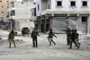 Syriske tropper går igennem gaderne i Aleppo. FN har oplysninger om, at civile, herunder kvinder og børn, bliver skudt på stedet. Foto: SANA via AP