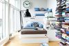 I den høje og smalle stue med det fantastiske lysindfald dominerer Arashs specialbyggede sofa i etager. Puder og hynder i blå og brun er syet af Kristinas svigermor og de smukke, mønstrede puder er fra Place de Bleu på Nørrebro. Uret er fra en banegård i Hamborg og købt brugt.