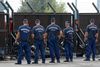 Ungarsk politi betragter migranter, der ser gennem grænsehegnet mod Serbien.