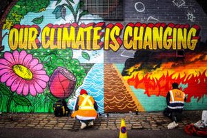Gadekunstnere ifærd med at udsmykke en mur i Glasgow, der er vært for FN's Klimatopmøde COP26. Foto: AFP/Andy Buchanan 