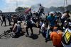 Demonstranter fra oppositionen under sammenstød med præsident Nicolas Maduros tropper omkring militærbasen La Carlota i Caracas tirsdag. Foto: Matias Delacroix/AFP