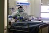 En sygeplejerske i fuld beskyttelsesdragt tager sig af en patient i Spanien. Nye tal viser, at i lande som Danmark, hvor samfundet er lukket hurtigt ned, har der ikke været overdødelighed. Foto: Sergio Perez/Reuters