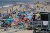 Mens mange i det sydlige Californien flokkes på strandene på grund af varmen, så er flere tusindvis brandfolk travlt beskæftiget med at få styr på flere naturbrande. Foto: John Antczak/AP Photo