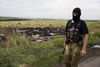 Efterforskningen er blevet alvorligt hæmmet af, at flyet styrtede ned i en krigszone. Her ses en prorussisk separatist ved nogle af vragdelene. Arkivfoto: Niclas Hammarström/Aftonbladet