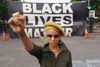 Black Lives Matter er blevet et globalt kampråb mod politivold og racisme. Her er det en demonstrant med løftet knytnæve foran et BLM-banner på gaden over for Det Hvide Hus. Foto: Kevin Lamarque/Reuters