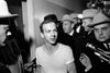 Kort efter drabet bliver Lee Harvey Oswald anholdt. Han udtaler sig til pressen, mens han føres gennem en politistation i Dallas. Foto: AP