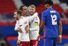 Yussuf Poulsen krammer de to 100-kampsjubilarer efter sejren over England. Foto: Toby Melville/Reuters