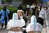 Sundhedspersonale i beskyttelsesdragter covidtester millioner af kinesere i Beijing i disse uger som led i den kinesiske nultolerancepolitik. Foto: Carlos Garcia Rawlins/Reuters