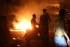 Demonstrators are pictured near burning fire during a protest near parliament, following Tuesday's blast in Beirut's port area, Lebanon August 7, 2020. REUTERS/Mohamed Azakir