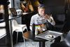 Hvis man træner nok og dermed forbrænder kalorier, er der ikke noget i vejen med et bagerstop undervejs på en lang træningstur. Her får Albert Withen Philipsen en træstamme og en kop kaffe hos Brødsnedkeren i Humlebæk. Foto: Gregers Tycho