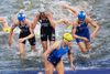 De Kvindelige triathleter stiger od af vandet efter en svømmetur langs seinen.