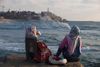 Et par israelsk-arabiske kvinder har gang i vandpiben på stranden ud til Middelhavet ved Tel Aviv. Ved dette valg gør de arabiske partier fælles front, og meningsmålinger spår partiet til at blive Knessets tredjestørste parti. Foto: Dan Balilty/AP