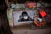 Graffti viser Brasliens præsident Jair Bolsonaro, der bærer en ansigtsmaske. Præsidenten bliver kritiseret for ikke at tage corona seriøst. Det har blandet andet fået de kriminelle bander til selv at indføre restriktioner i favelaerne. Foto: Mauro Pimentel/AFP