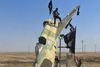 Medlemmer af Islamisk Stat ved et nedstyrtet jagerfly fra det syriske luftvåben nær Raqqa, IS’s hovedby i Syrien. Her har de islamiske ekstremister hidtil kunnet være nogenlunde i fred for luftangreb.